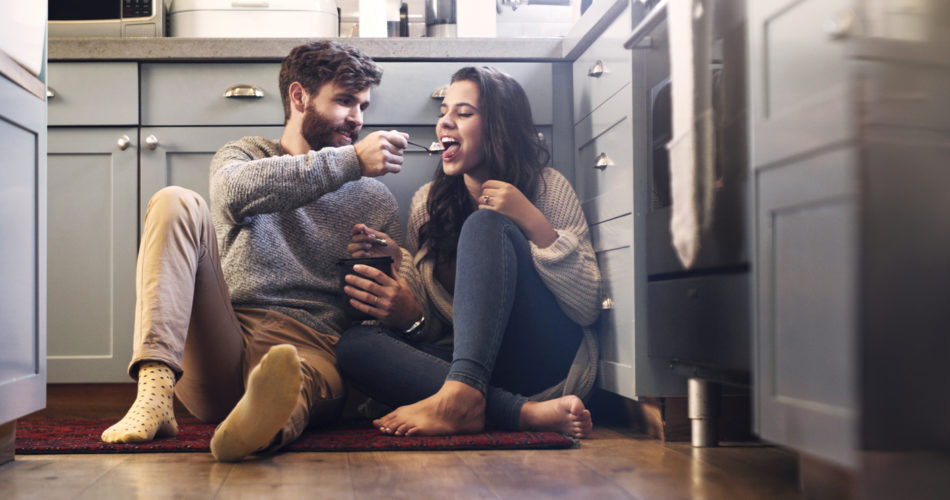 Couple eating ice cream together in the kitchen