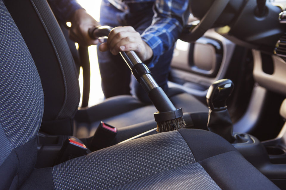 Man vacuuming car interior