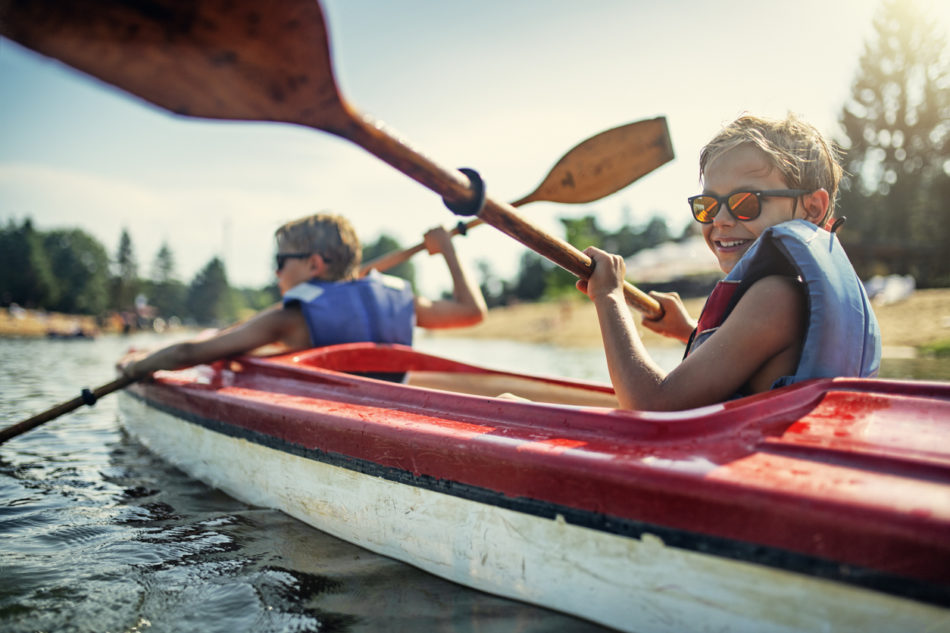 Two young boys kayaking on a summer day