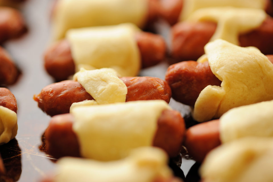 Close up of cooked pigs in a blanket sausage rolls.