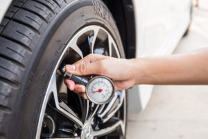 Hand holding pressure gauge for car tyre pressure measurement