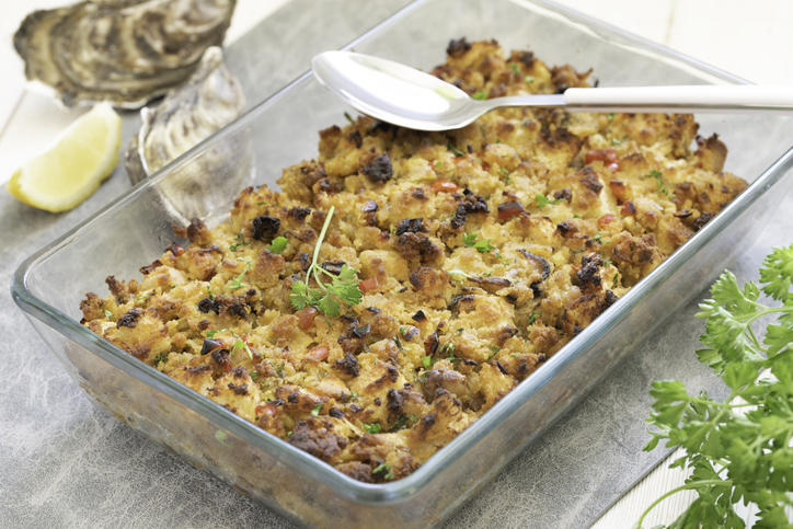 Homemade oyster cornbread stuffing in a Southern-style cornbread dressing made with red bell pepper, celery, onion, herbs, crumble cornbread, cubed white bread and oyster served for a traditional Southern Thanksgiving