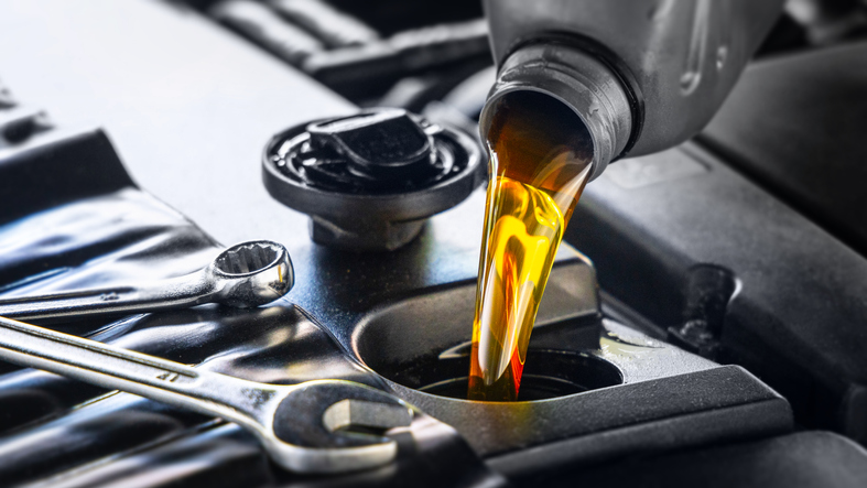 Pouring motor oil for motor vehicles from a gray bottle into the engine, ,  oil change,  auto repair shop, service,