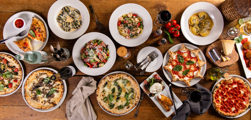 Big dinner table with italian food, pizzas and pastas, appetizers and wine, banner size