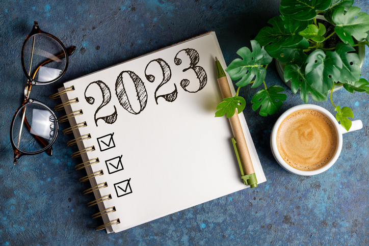 New year resolutions 2023 on desk. 2023 resolutions list with notebook, coffee cup on table. 